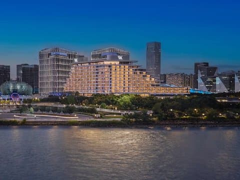 Waldorf Astoria Shanghai Qiantan nachts beleuchtet am Fluss