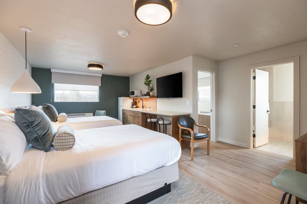 Renovated guest room with two beds and kitchenette at Adobe Desert Motel